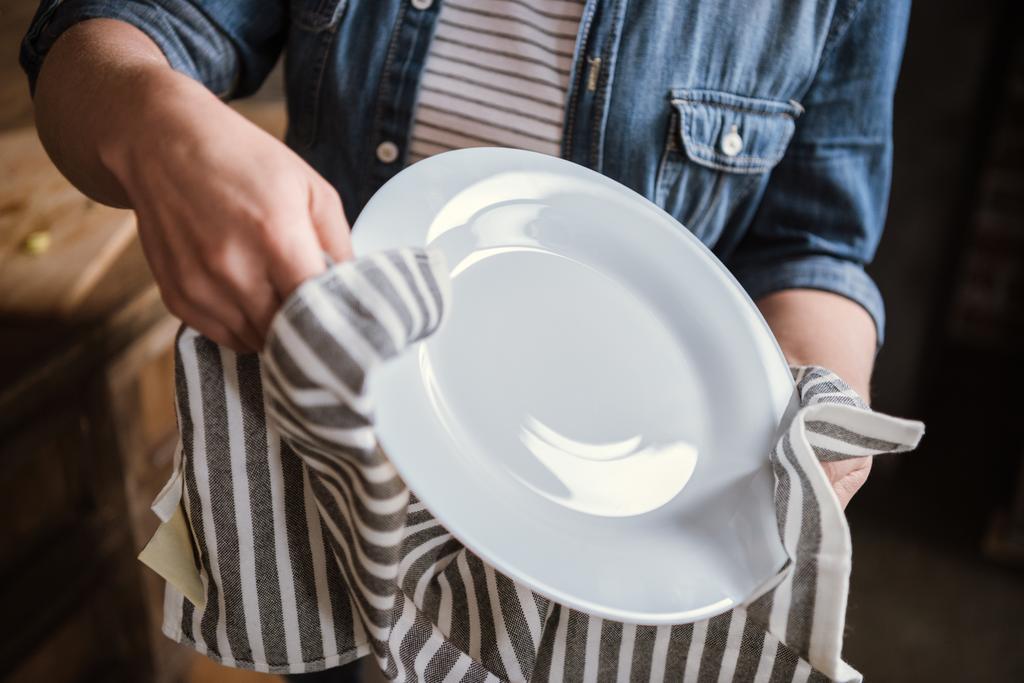 Женщина вытирает тарелку
 - Фото, изображение