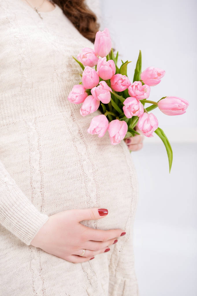 Kobieta w ciąży z bukiet dzwon touch tulipany. z bliska - Zdjęcie, obraz