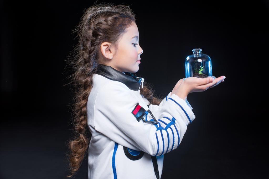 Girl astronaut holding plant - Photo, Image