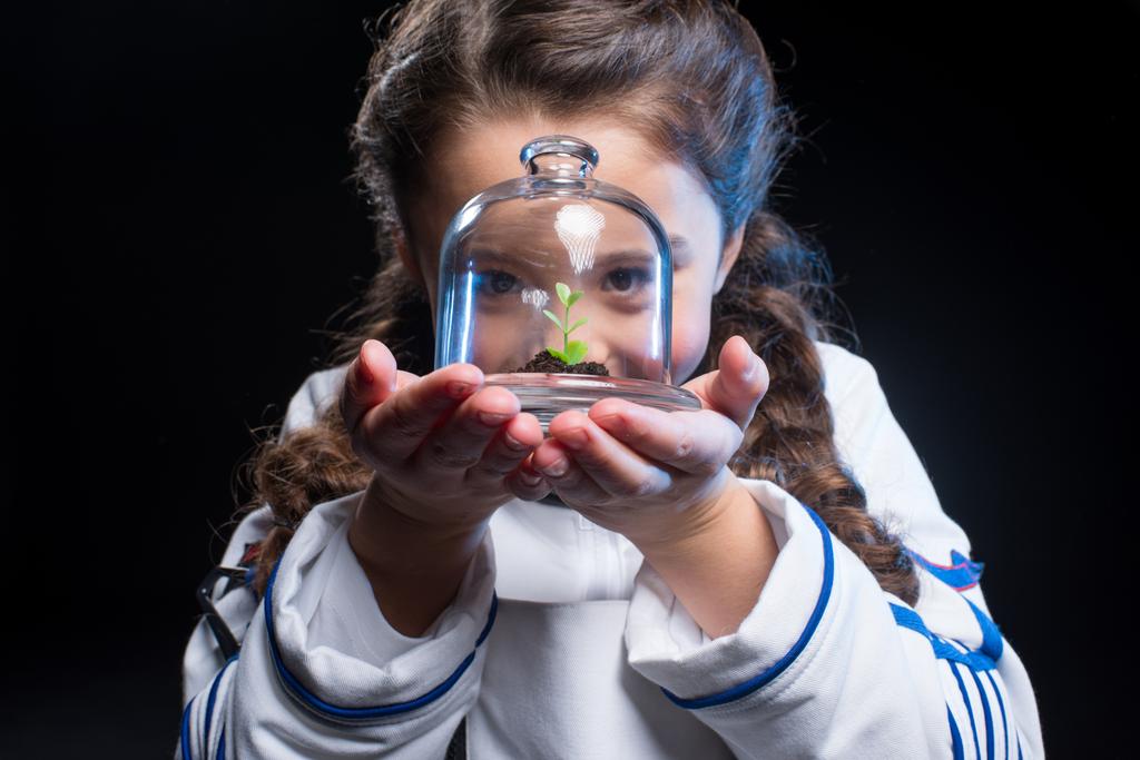 Tyttö astronautti holding kasvi
 - Valokuva, kuva