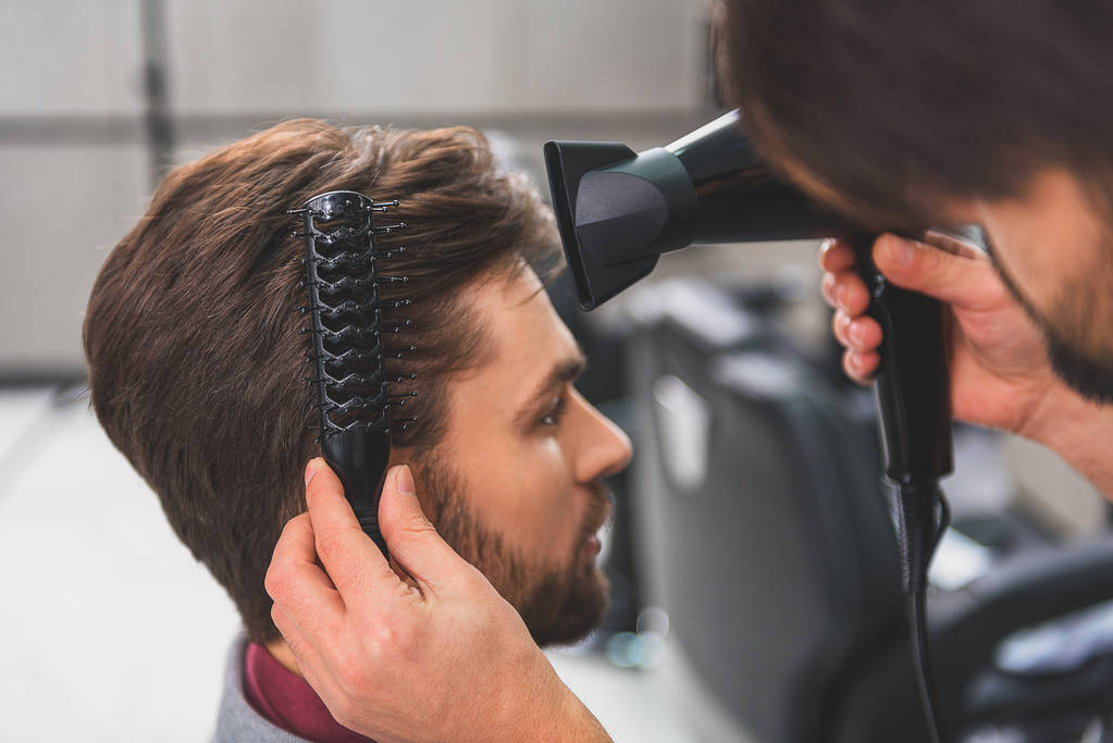 Friseur mit Haartrockner im Schönheitssalon - Foto, Bild