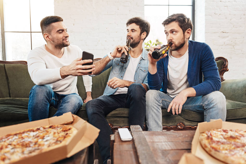 Handsome pleasant men taking a sip of beer - Photo, Image
