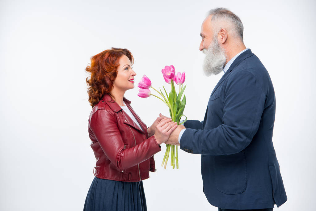 Hombre presentando flores a la mujer
   - Foto, imagen