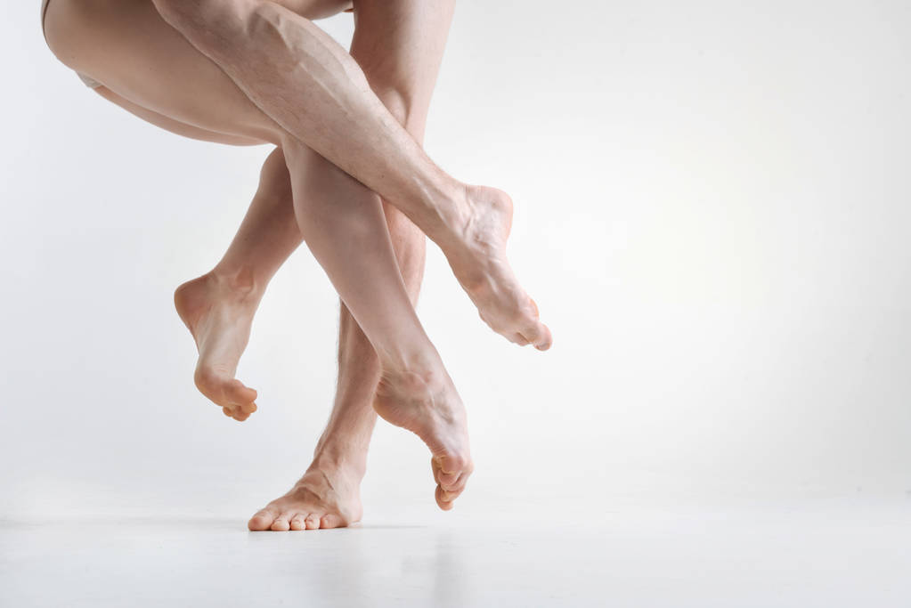 Χαριτωμένη αριστοτεχνική χορευτές πόδια εκτελεί στο λευκό χρώμα δωμάτιο - Φωτογραφία, εικόνα