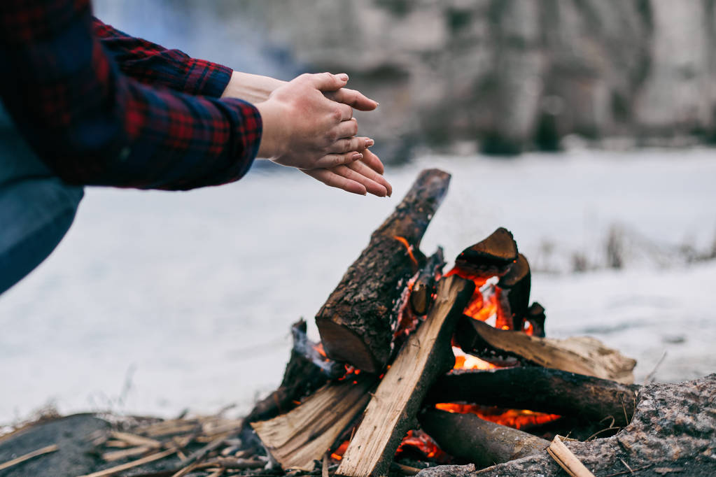 Fille réchauffe les mains près d'un feu en hiver
 - Photo, image