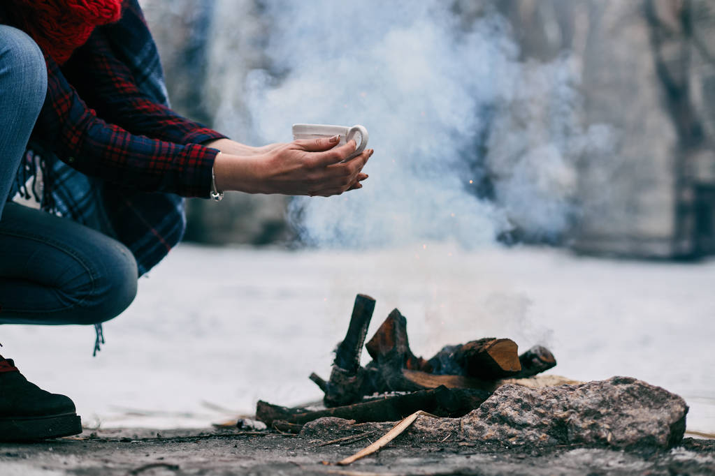 La ragazza si scalda mani vicino a un fuoco in inverno
 - Foto, immagini