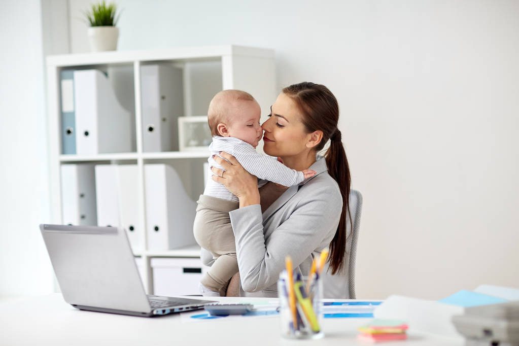 赤ちゃんとオフィスでラップトップを幸せな実業家 - 写真・画像