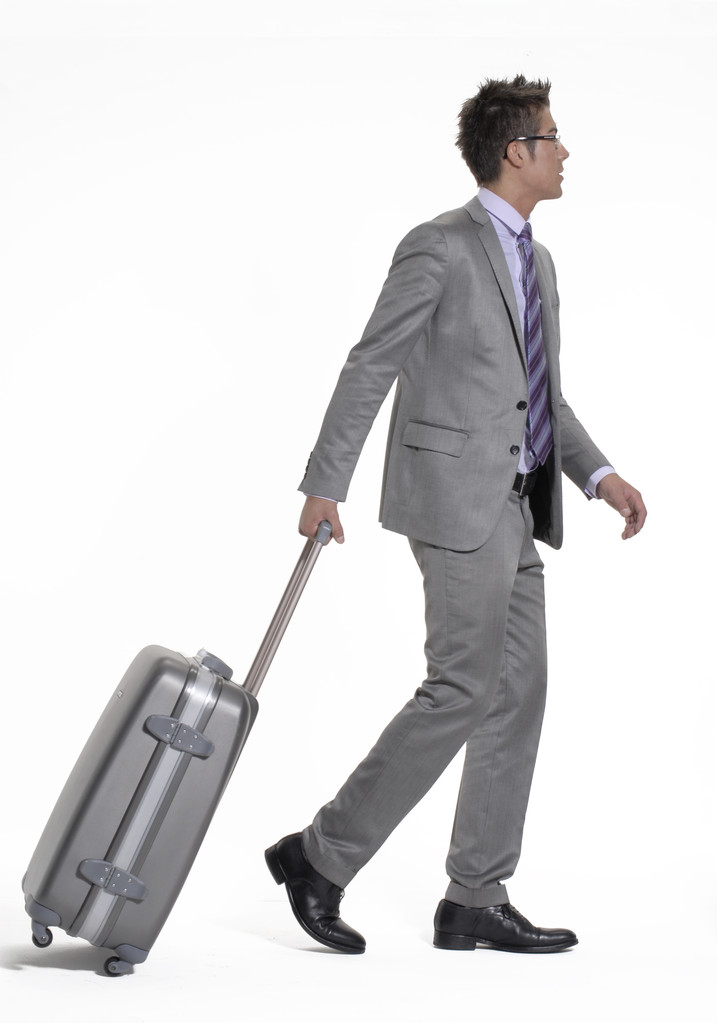 Молодий бізнесмен ходить і тягне свій багаж
. - Фото, зображення