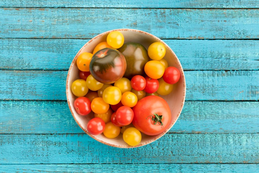 Tomates em tigela na mesa
 - Foto, Imagem