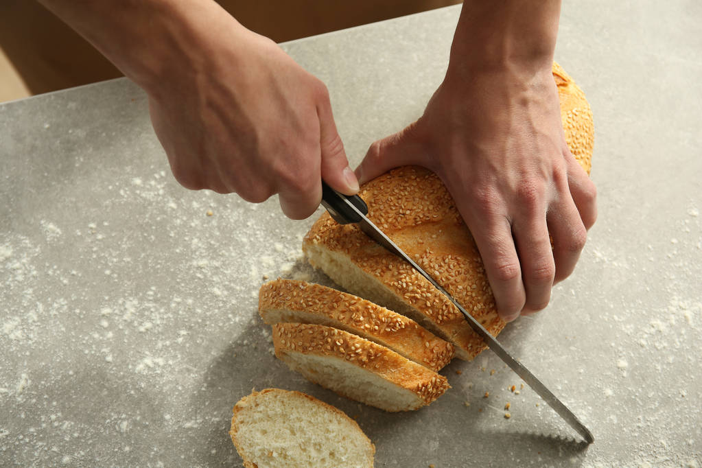 Miesten kädet leikkaamalla leipää
 - Valokuva, kuva