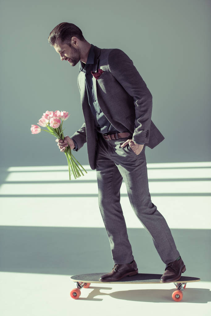 fashionable man holding tulips - Foto, afbeelding