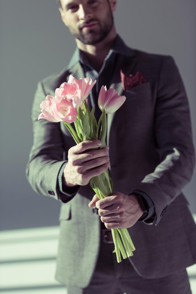 stylish man holding tulips - Photo, Image
