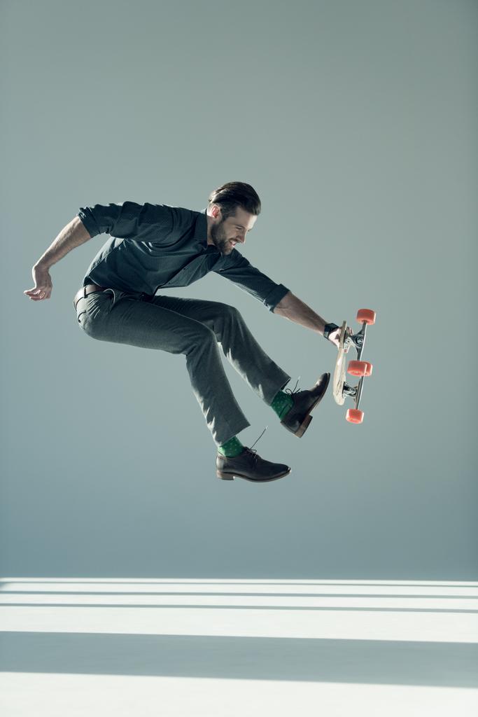 homme à la mode tenant skateboard
  - Photo, image
