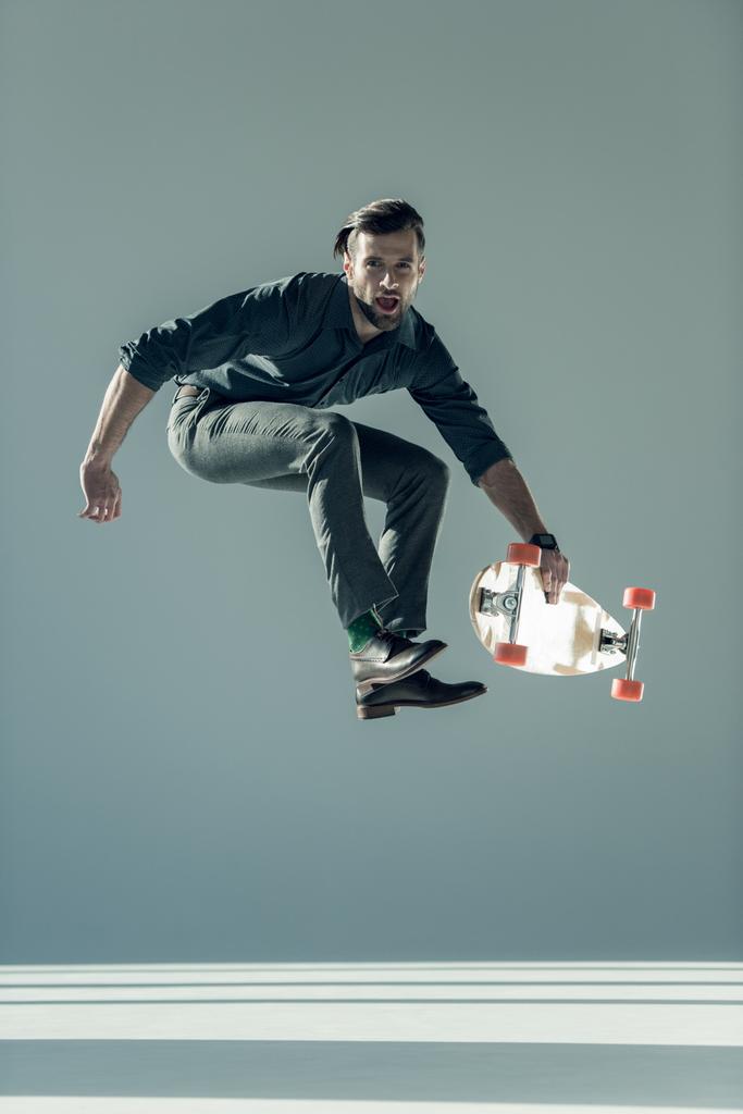 fashionable man holding skateboard  - Foto, afbeelding