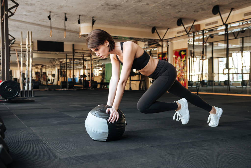 Sportswoman working out with ball in gym - Photo, Image