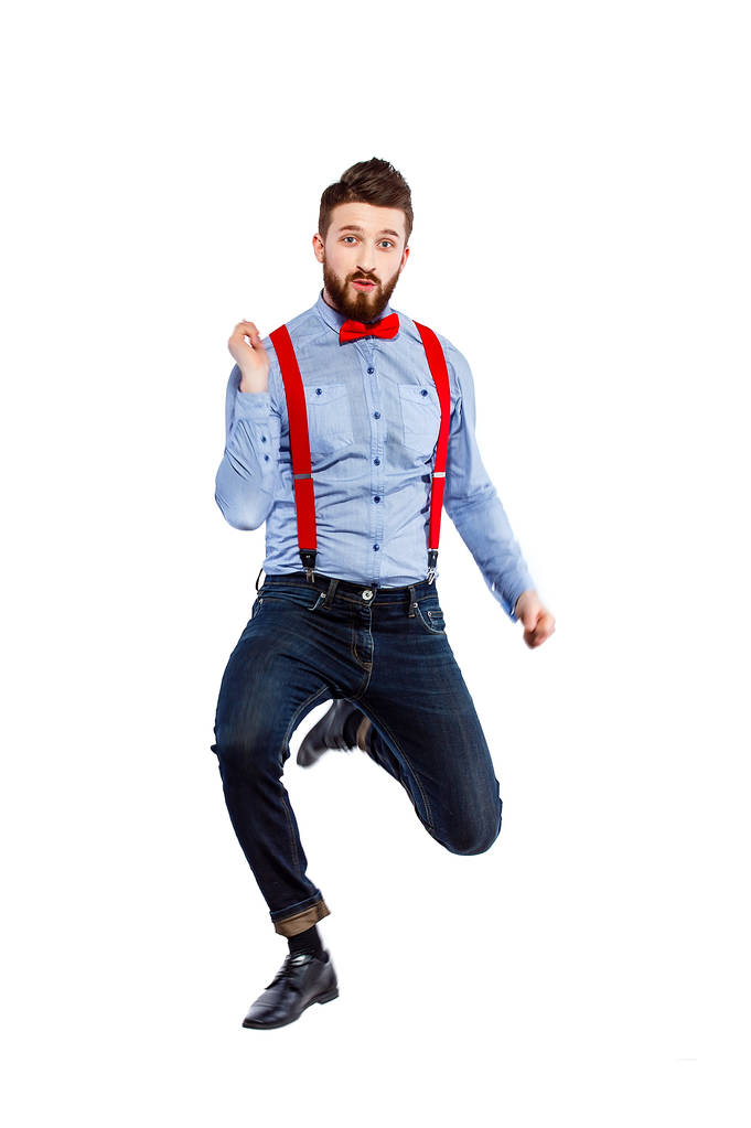 stylischer Typ im blauen Hemd mit roter Fliege und Hosenträgern iso - Foto, Bild