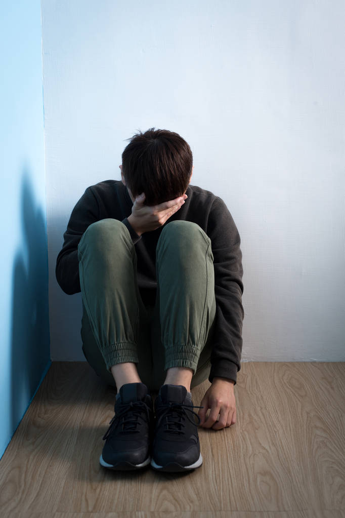 Hombre deprimido sentado en el suelo
 - Foto, Imagen