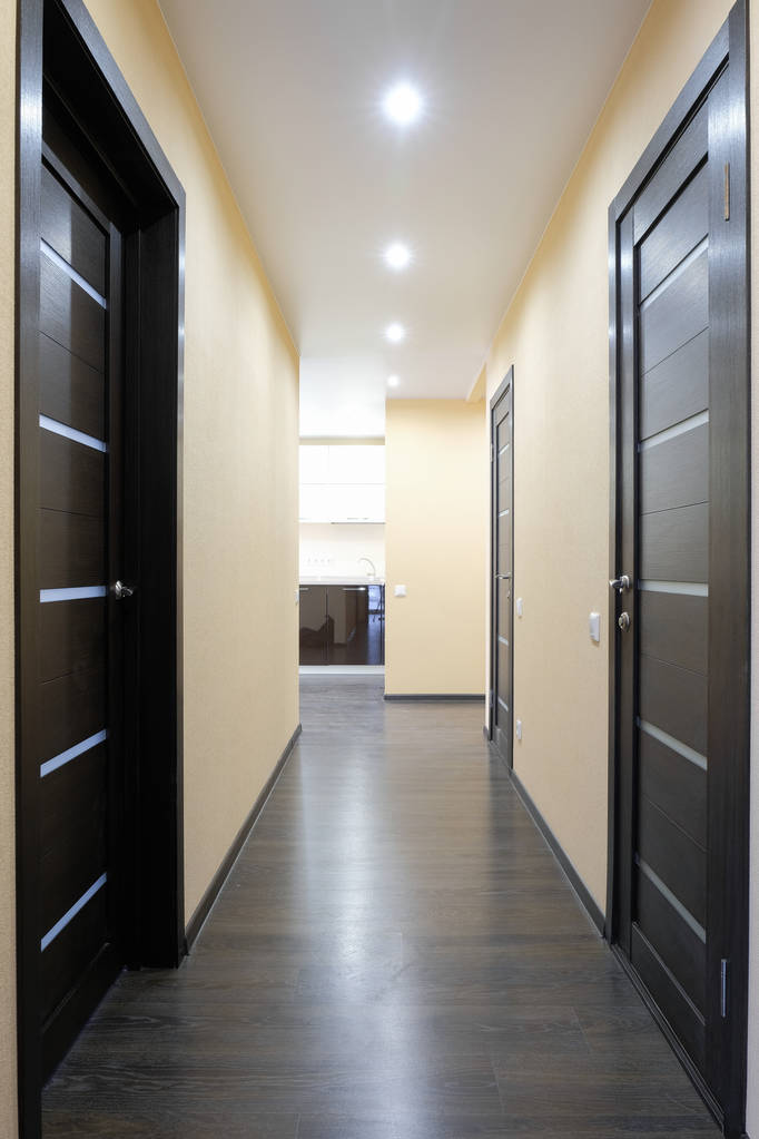 Снимок коридора с тремя деревянными дверями
 - Фото, изображение