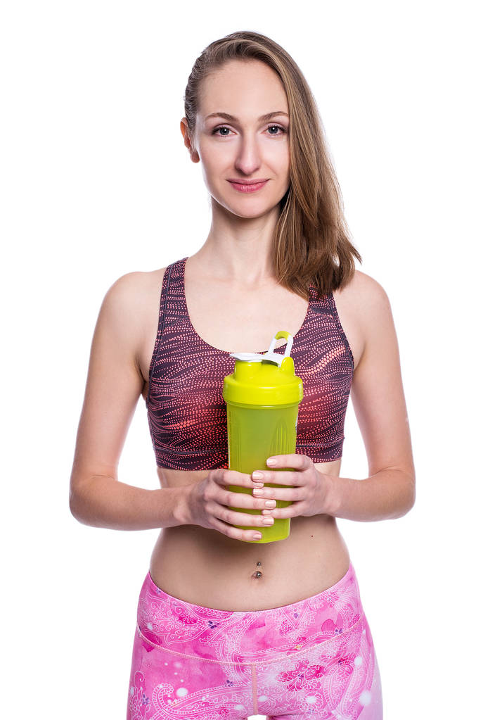 Felice donna sportiva con shaker verde guardando la fotocamera in studio. Isolato su sfondo bianco
. - Foto, immagini