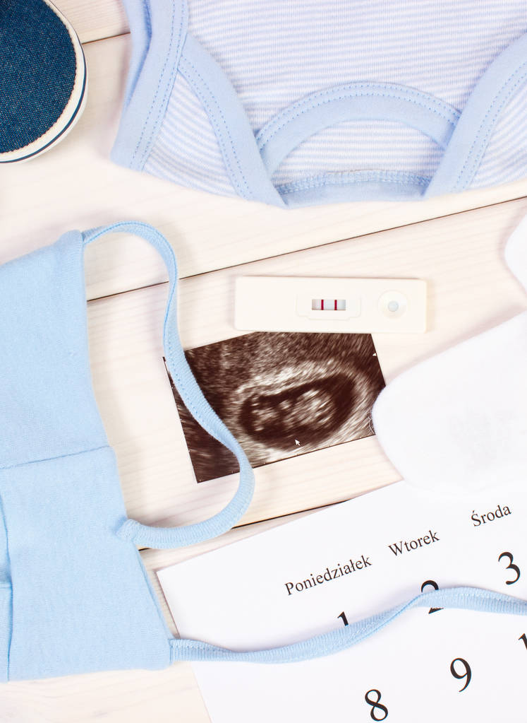 Teste de gravidez, ultra-som do bebê, roupas para recém-nascido e calendário, esperando para o bebê
 - Foto, Imagem