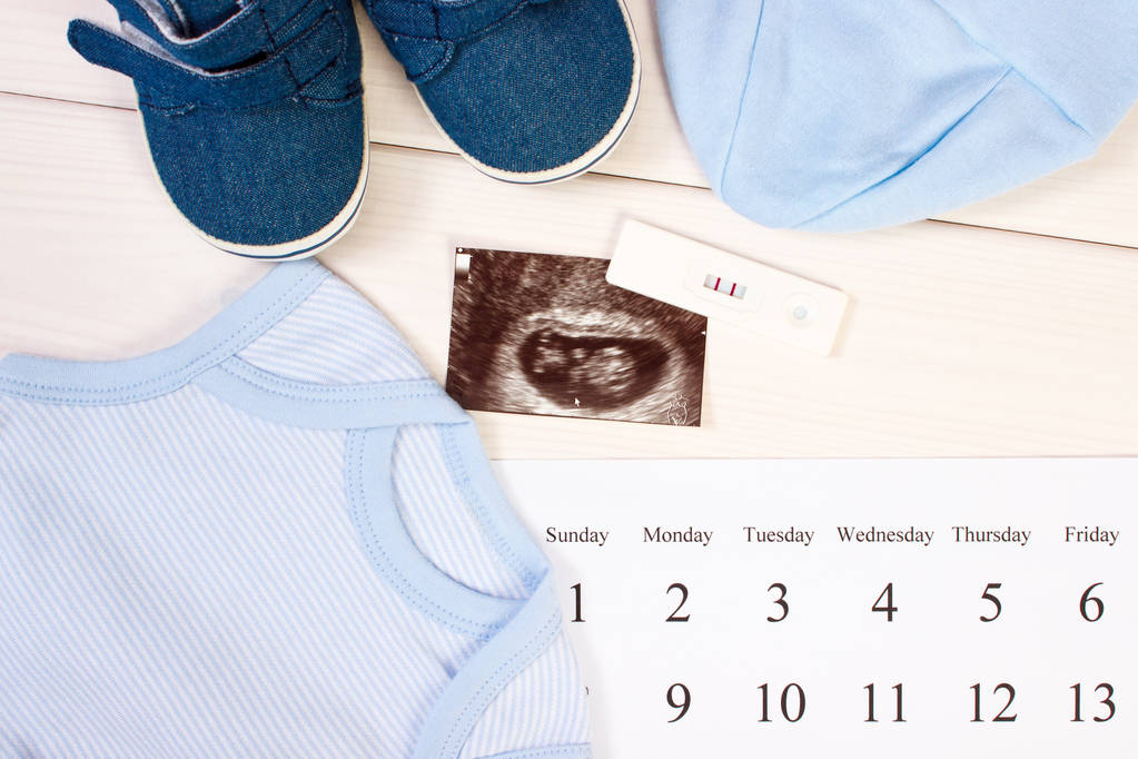 Teste de gravidez, ultra-som do bebê, roupas para recém-nascido e calendário, esperando para o bebê
 - Foto, Imagem