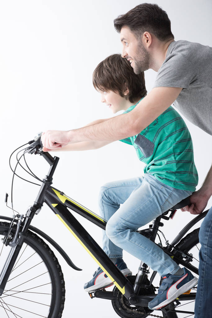 Vater hilft Sohn beim Fahrradfahren - Foto, Bild
