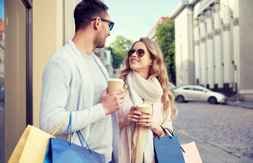 pareja feliz con bolsas de compras y café en la ciudad
 - Foto, Imagen