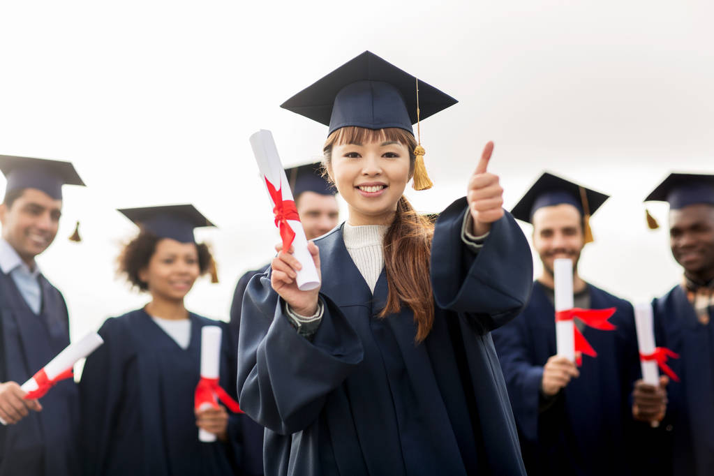 счастливые студенты с дипломами показывая большие пальцы вверх
 - Фото, изображение