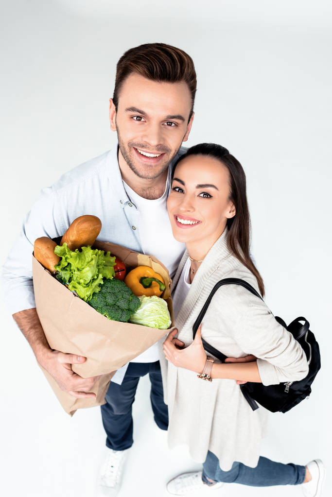 食料品の袋と若いカップル - 写真・画像