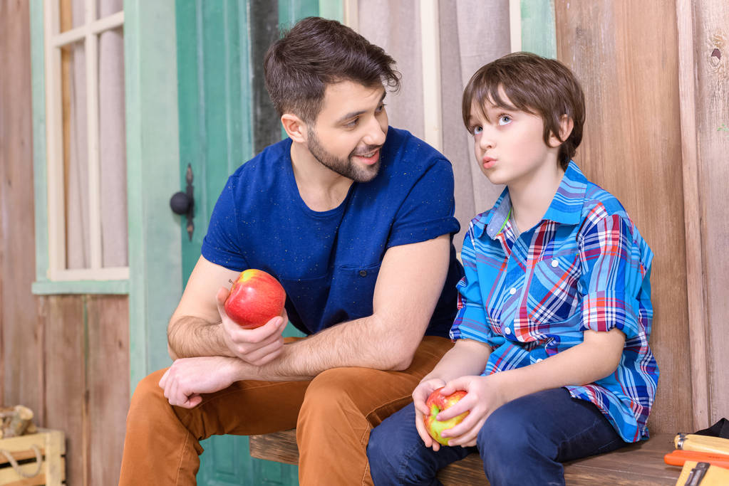 Батько і син їдять яблука
 - Фото, зображення