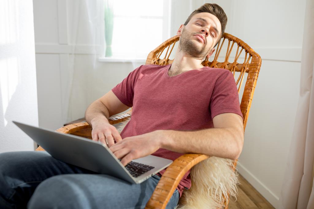 Uomo con laptop in sedia a dondolo
 - Foto, immagini