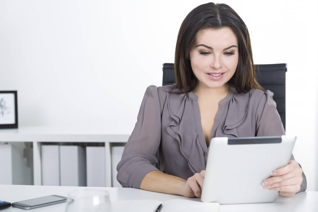 Крупним планом жінка в сірому кольорі з планшетом
 - Фото, зображення