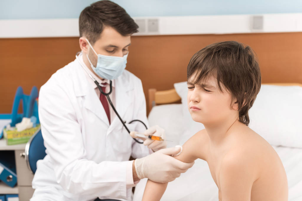 Médecin faisant l'injection au garçon
 - Photo, image