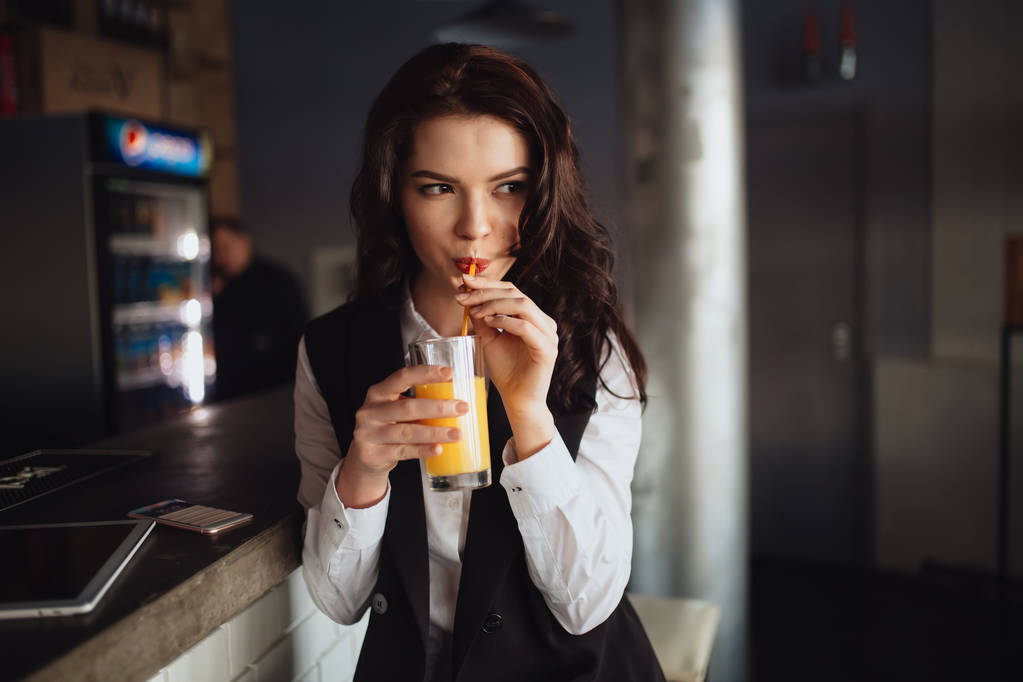 Υγιεινή διατροφή - νεαρή γυναίκα πίνοντας χυμό πορτοκαλιού στο εστιατόριο-μπαρ - Φωτογραφία, εικόνα