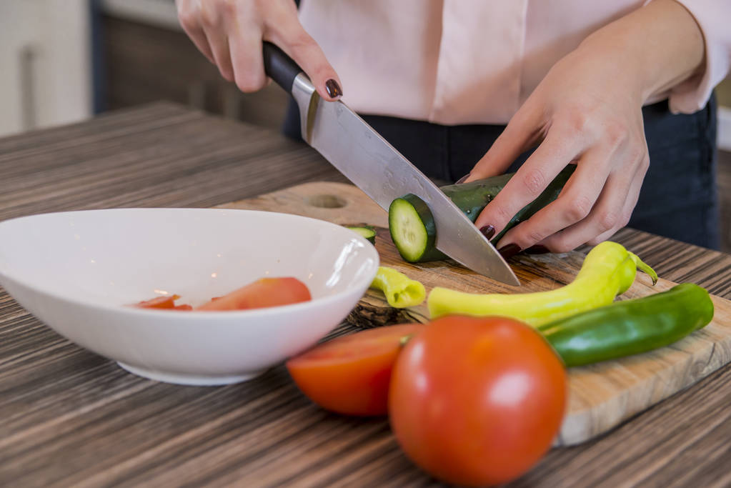 Młoda kobieta krojenia warzyw w kuchni w domu, ludzkich rąk, gotowanie Sałatka warzywa w kuchni. Piękne dziewczyny, przygotowywaniu niskokalorycznych przekąsek z świeżymi warzywami - Zdjęcie, obraz