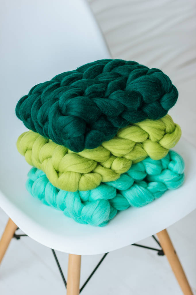 Bufandas de lana merino de punto colorido en silla blanca
 - Foto, Imagen