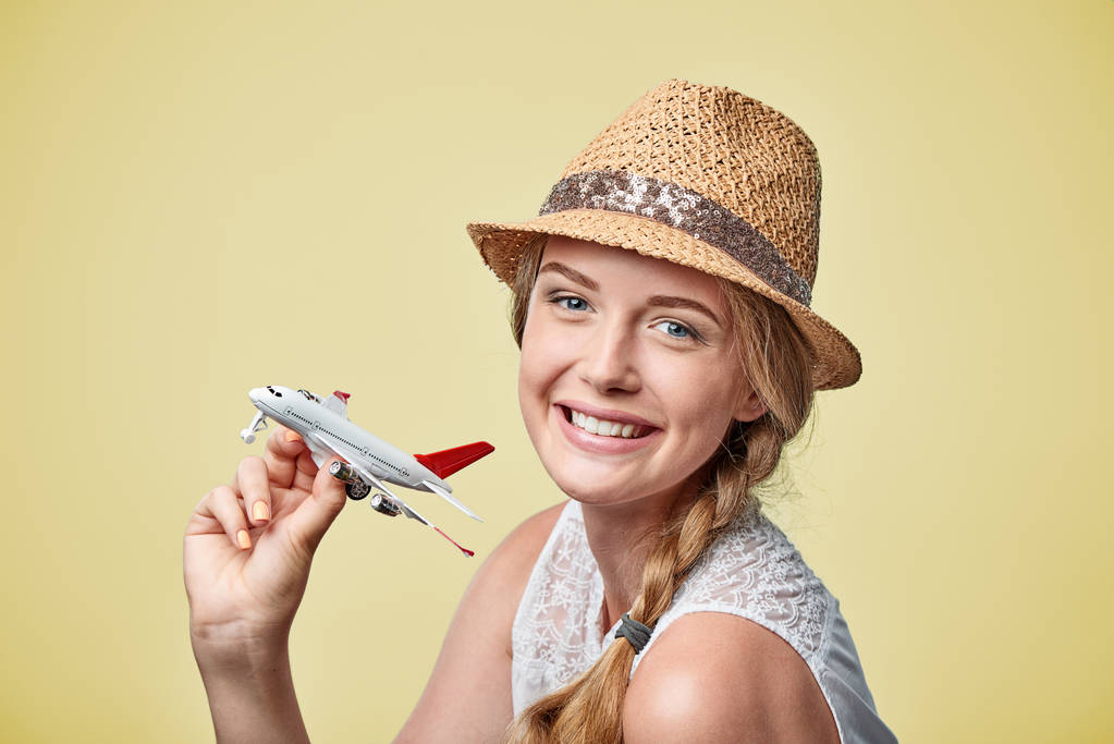 Женщина в соломенной шляпе держит в руках модель самолета
 - Фото, изображение