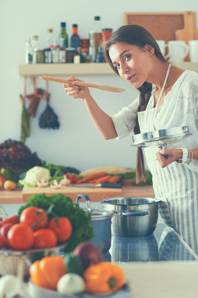 Kochende Frau in Küche mit Kochlöffel - Foto, Bild