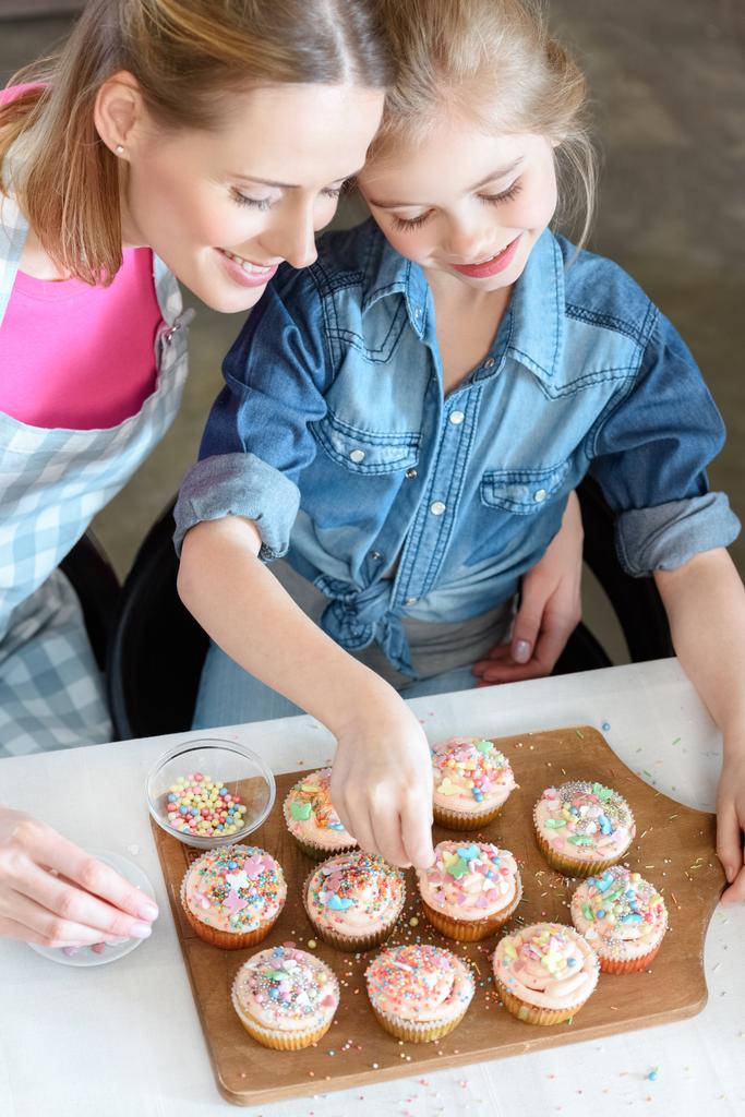 母と娘のカップケーキを焼く - 写真・画像