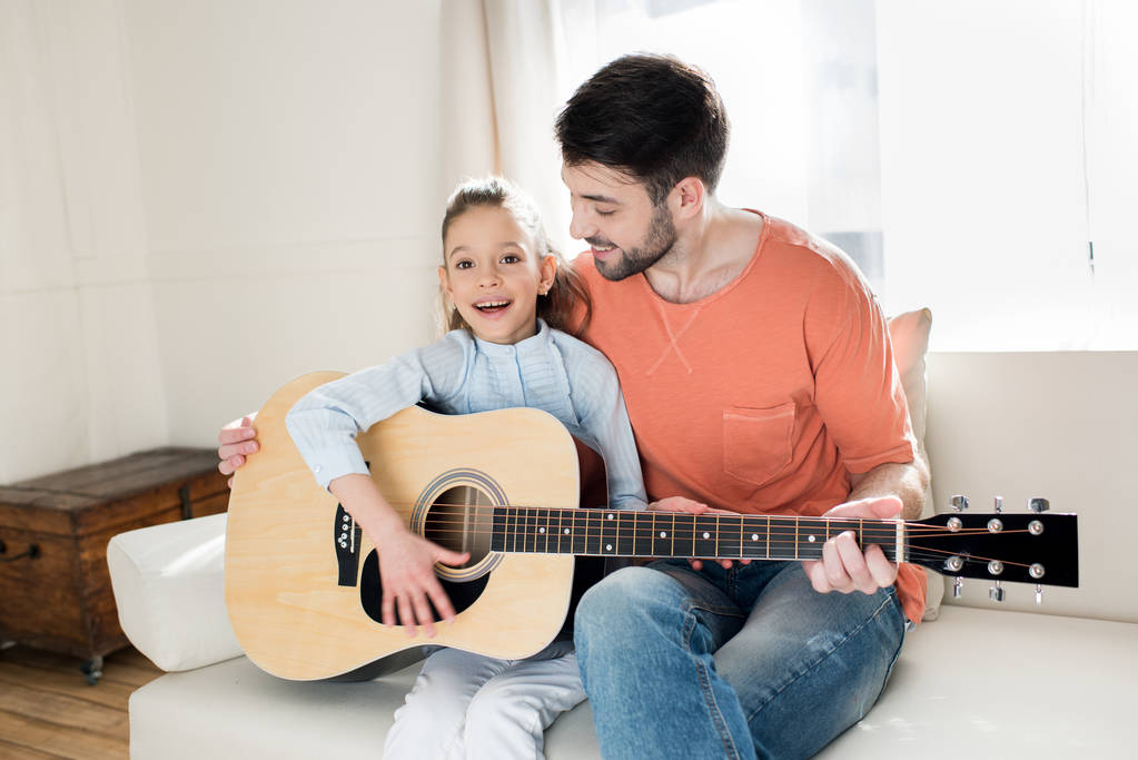 Батько і дочка грають на гітарі
 - Фото, зображення