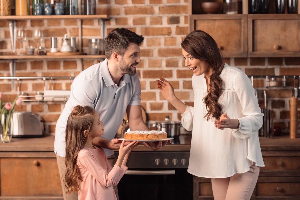 familia con pastel en la cocina
 - Foto, imagen