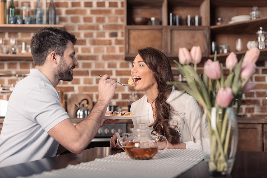 Side View Of Smiling Man Feeding Woman Free Stock Photo and Image