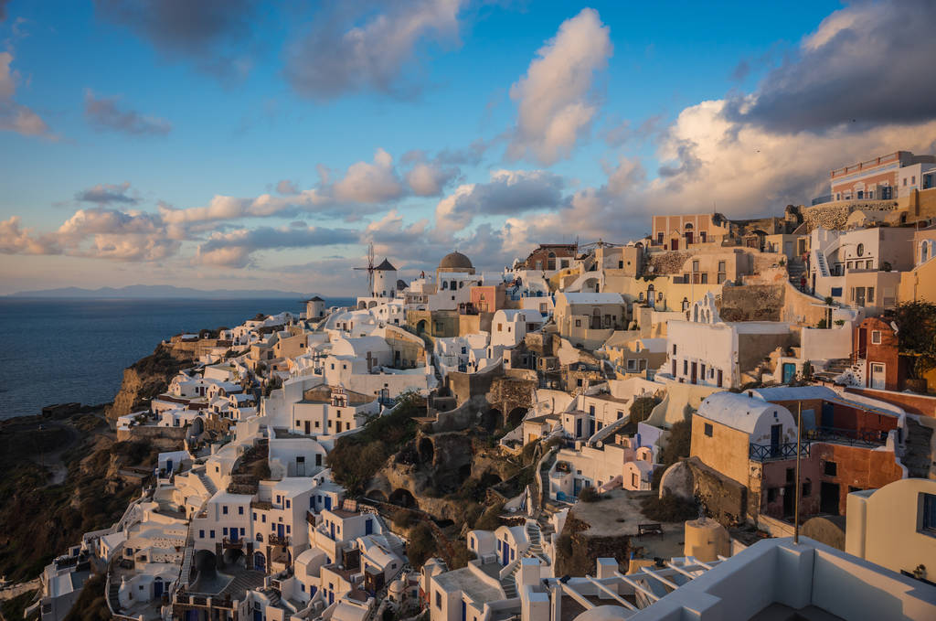 weiße Stadt am Hang eines Hügels bei Sonnenuntergang, oia, santorini, greec - Foto, Bild