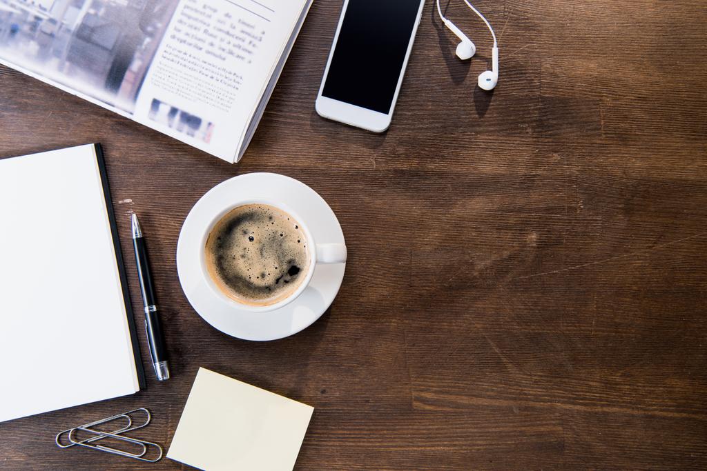 Koffiekopje en smartphone op Bureau - Foto, afbeelding
