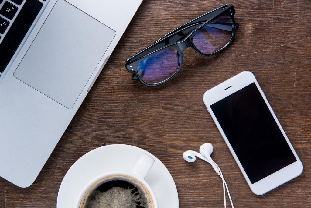 Kaffeetasse und Smartphone auf dem Schreibtisch  - Foto, Bild
