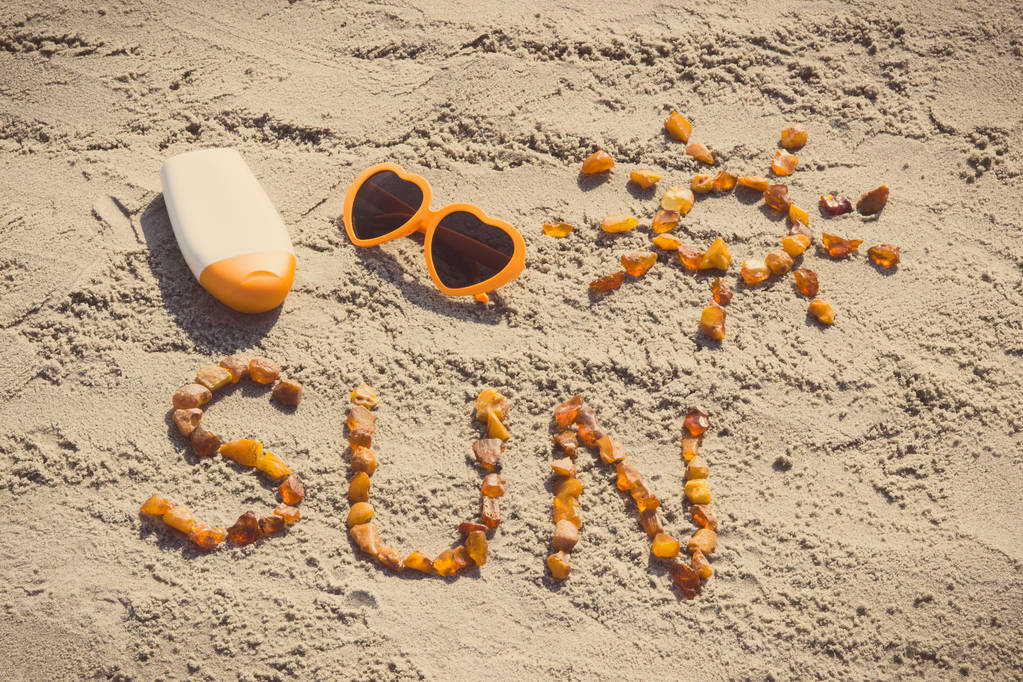 Photo vintage, Mot et forme du soleil, lunettes de soleil avec crème solaire sur le sable à la plage, heure d "été
 - Photo, image