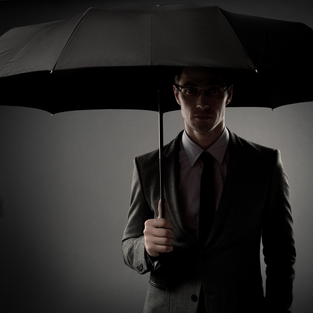 Empresário em traje segurando guarda-chuva preto
 - Foto, Imagem