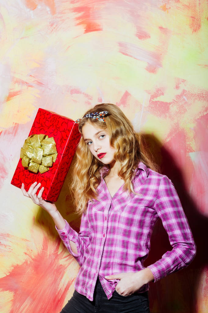 Kaunis tyttö punainen lahja laatikko kultainen keula
 - Valokuva, kuva