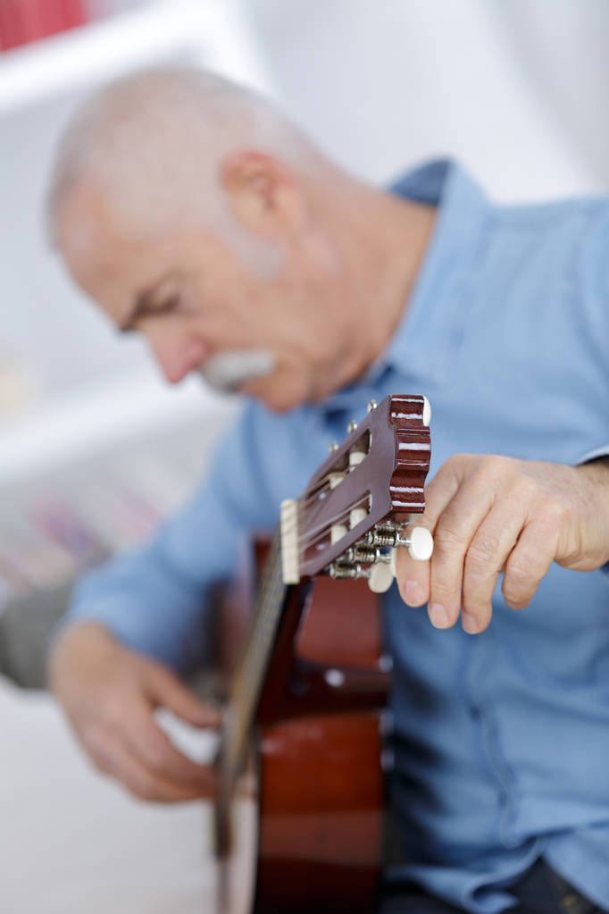 portré egy szép magas rangú ember játszik akusztikus gitár - Fotó, kép