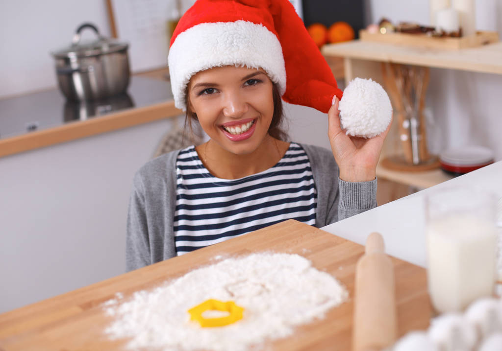 Boldog fiatal nő mosolyog boldog szórakozás karácsonyi előkészületek visel Mikulás kalap - Fotó, kép